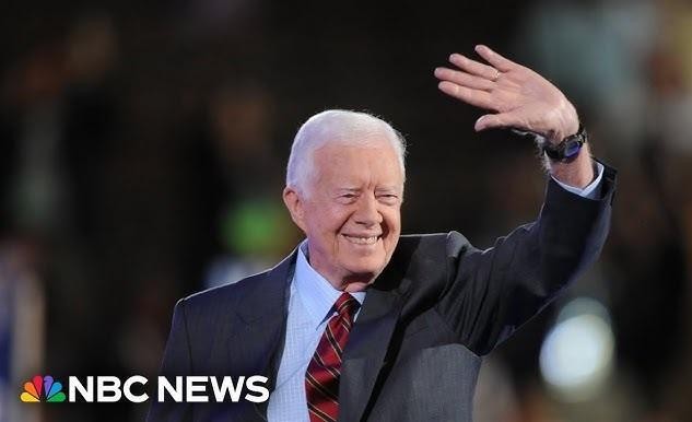 Ciepłe, autentyczne zdjęcie Jimmy'ego Cartera i Rosalynn Smith Carter w ich późniejszych latach, siedzących razem i delikatnie się uśmiechających, symbolizujące ich trwałe partnerstwo.